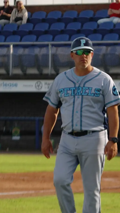 3rd base coach walking into position
