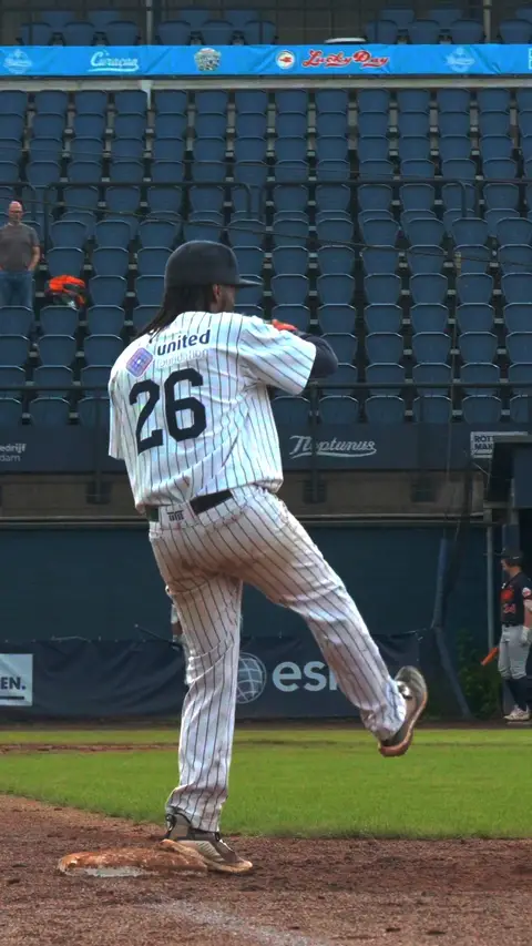 Gregory Trinidad throws from first base and smiles to the camera